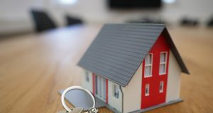 white and red wooden house miniature on brown table