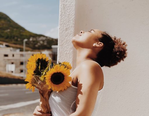 woman holding sunflower in vase